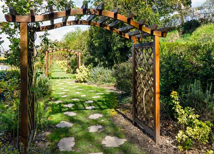 Outdoor garden with arbor, hedge plants, and flowers