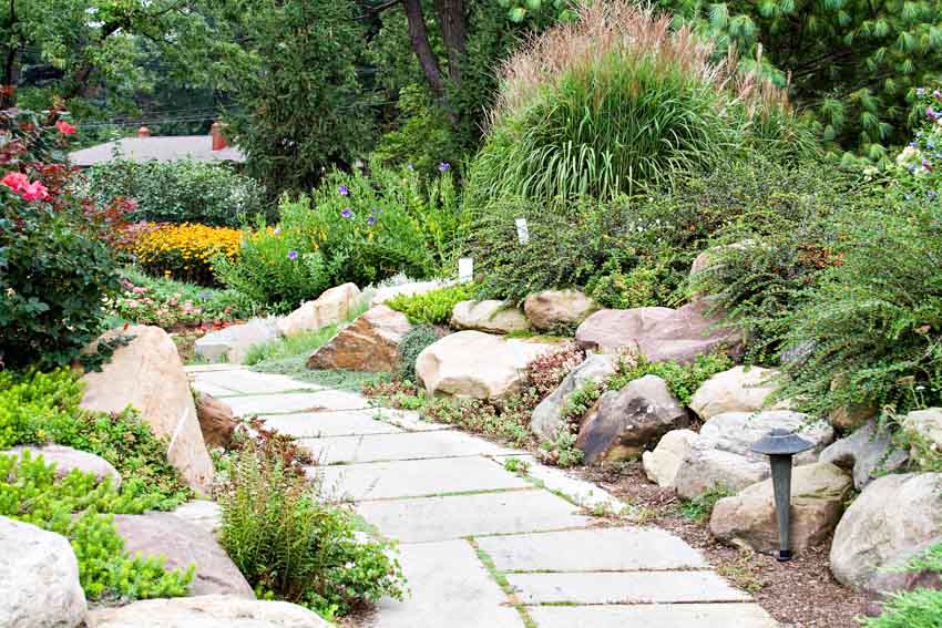 Outdoor garden with walkway, flowers, plants, and landscaping rocks