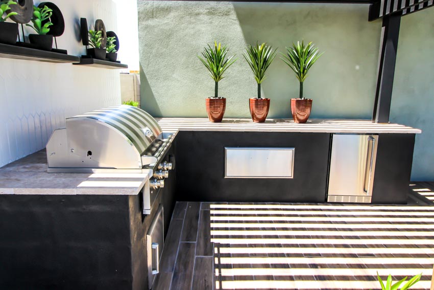 Outdoor kitchen with plants, barbecue grill, and epoxy countertop