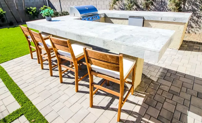 Outdoor patio with natural stone tile surface, table, and chairs