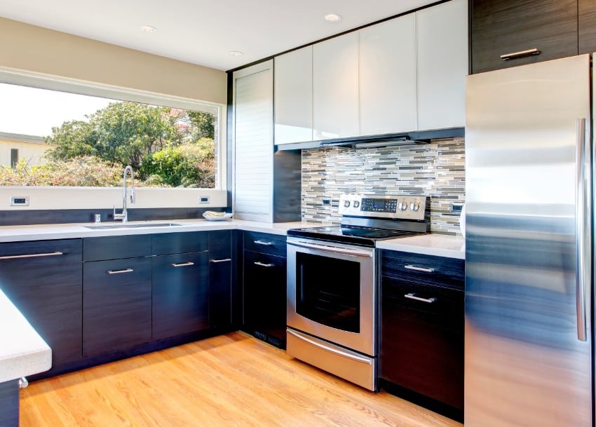 Simple kitchen with stainless steel appliances, dark cabinets and glass tile backsplash