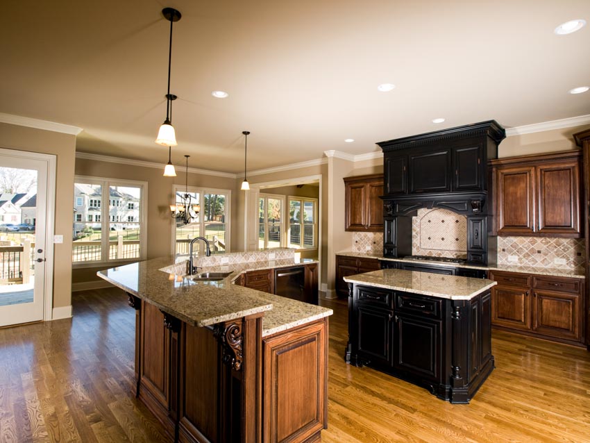 Spacious kitchen with center island, limestone backsplash, wood cabinets, pendant lights, and wooden flooring