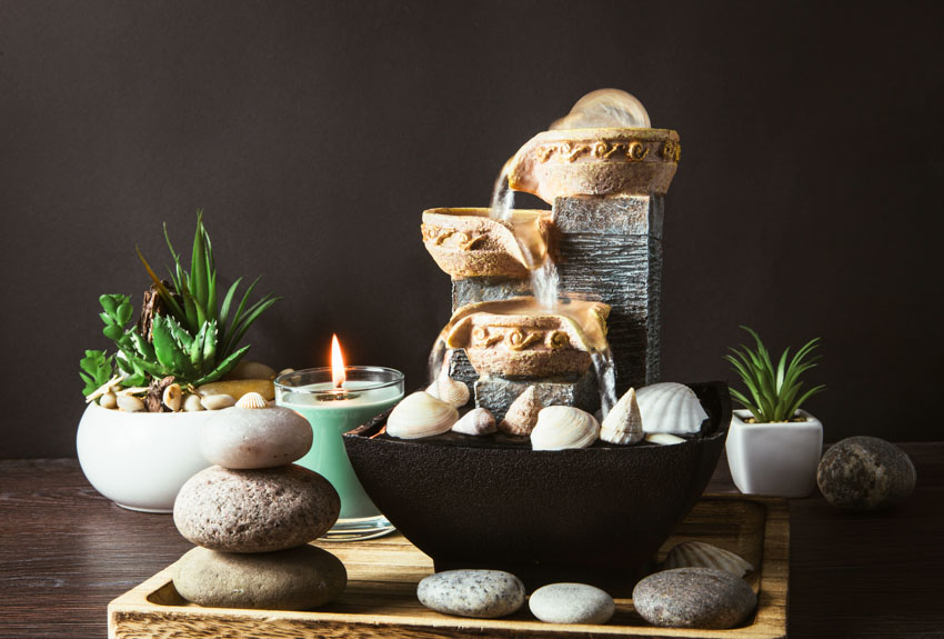 Tabletop fountain with candle, plants, and rocks for home interiors