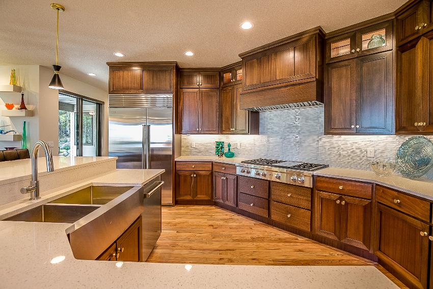Traditional kitchen design features huge round island with sink, hardwood plywood kitchen cabinets and hardwood floors