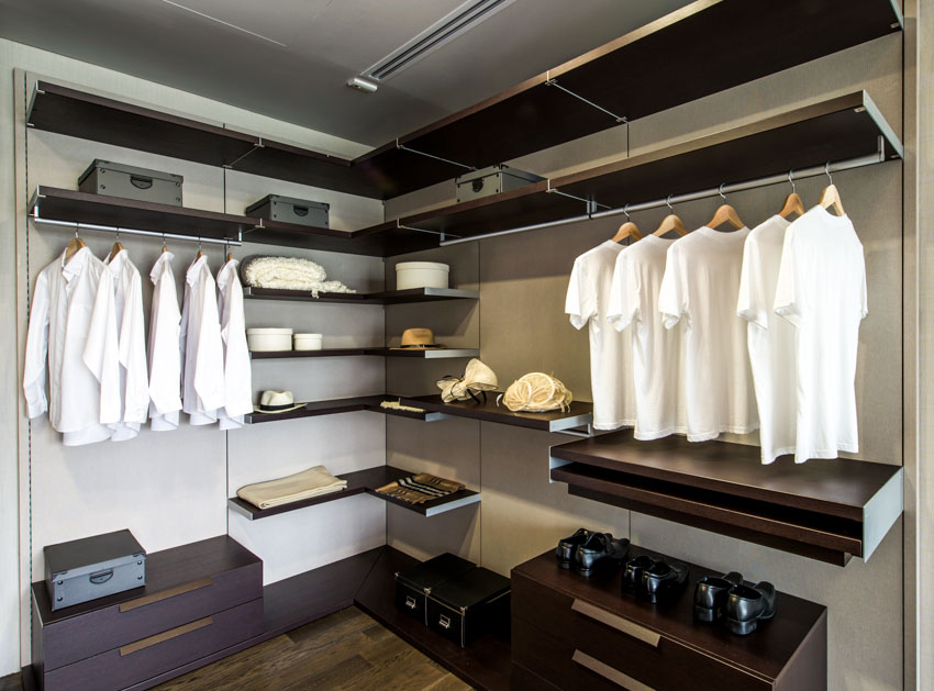 Men's walk-in closet with wood shelves, drawers, and hangers