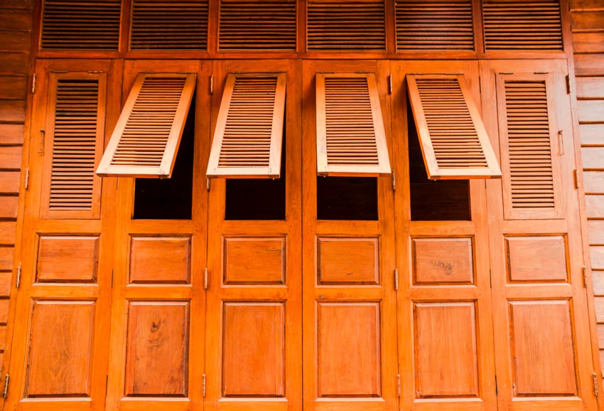 Wood louvered garage doors with opened windows for ventilation