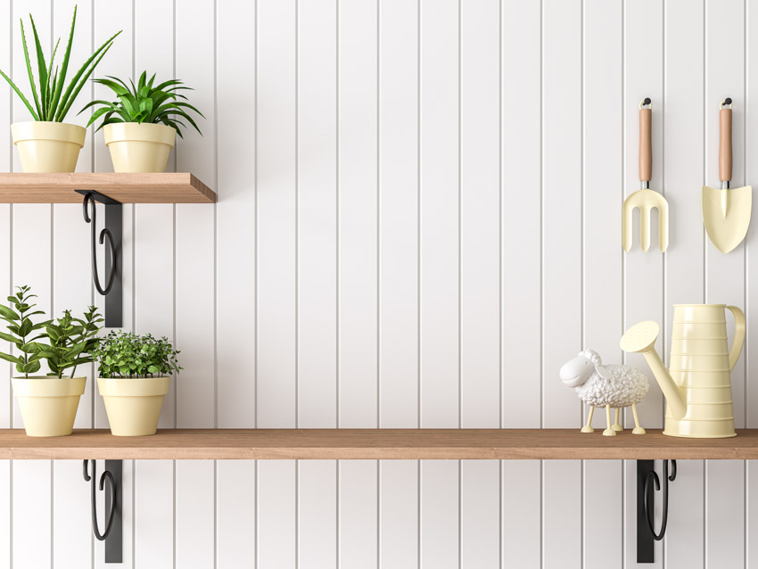 Shelves attached to shiplap wall with gardening tools