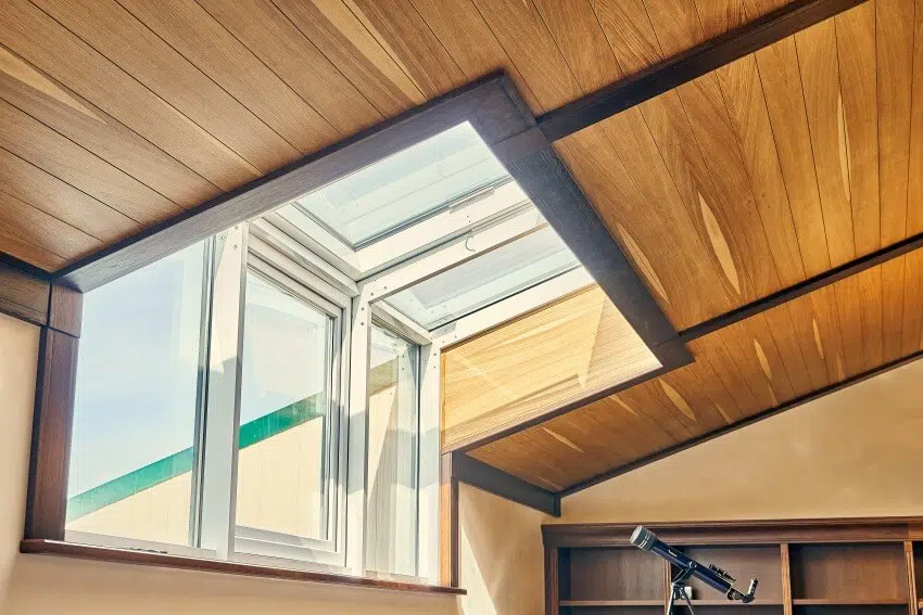 Attic with wooden shiplap ceiling and large window 