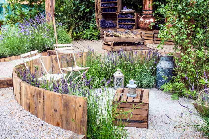 Backyard with decomposed granite patio, pallet seats, outdoor decor fixtures, and plants