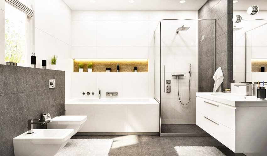 Bathroom with granite shower wall, tub, toilet bidet, vanity area, countertop, mirror, and windows