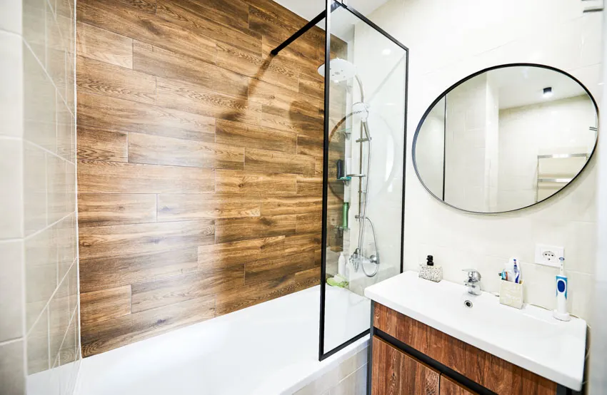 Bathroom with laminate wall panel shower, showerhead, sink, and mirror