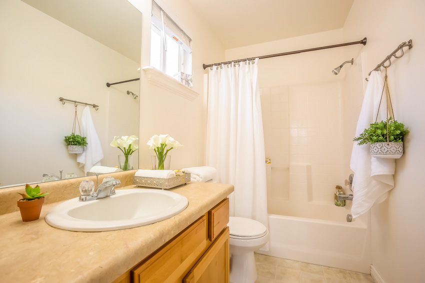 Bathroom with a shower rod, vanity area, and vanity mirror