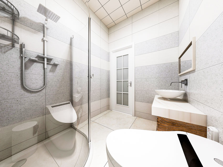 Bathroom with showerhead, glass divider, toilet, sink, mirror, ceiling tiles, and granite shower wall