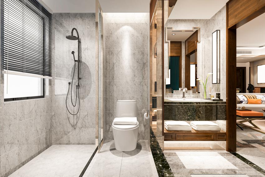 Bathroom with toilet, window blinds, vanity area, mirror, countertop, and granite shower wall