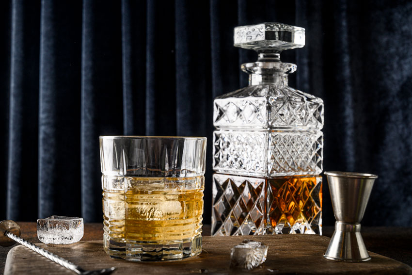 Decanter, whiskey glass and a stainless steel jigger