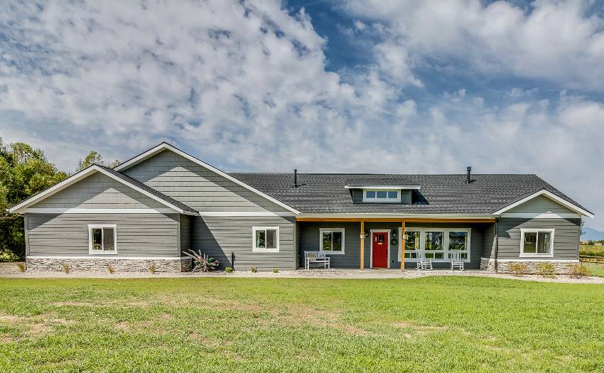 Beautiful gray ranch style home with red front door and big lawn
