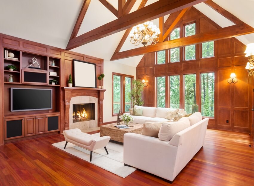 A beautiful living room interior with mahogany floors and fireplace in new luxury home with built in television and vaulted ceilings