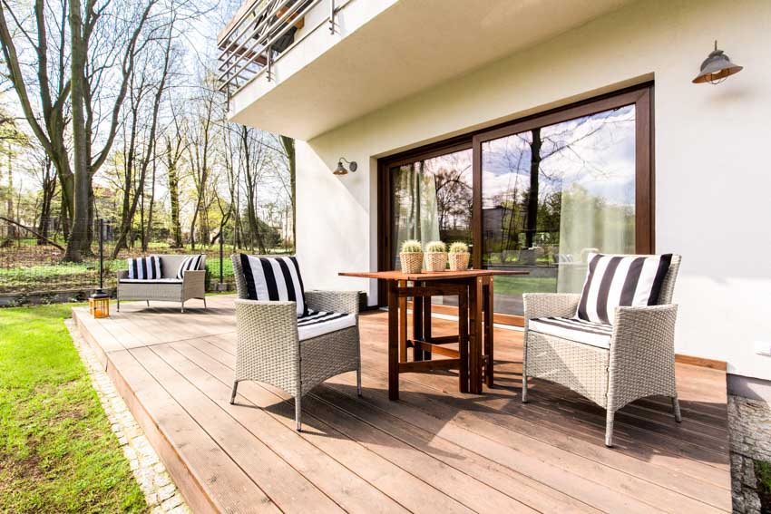 Beautiful pressure treated wood deck with accent chairs, table, and glass sliding doors