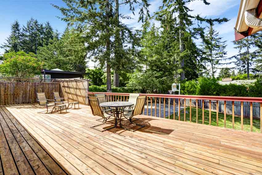 Beautiful pressure treated wood deck with chairs, table, and railings