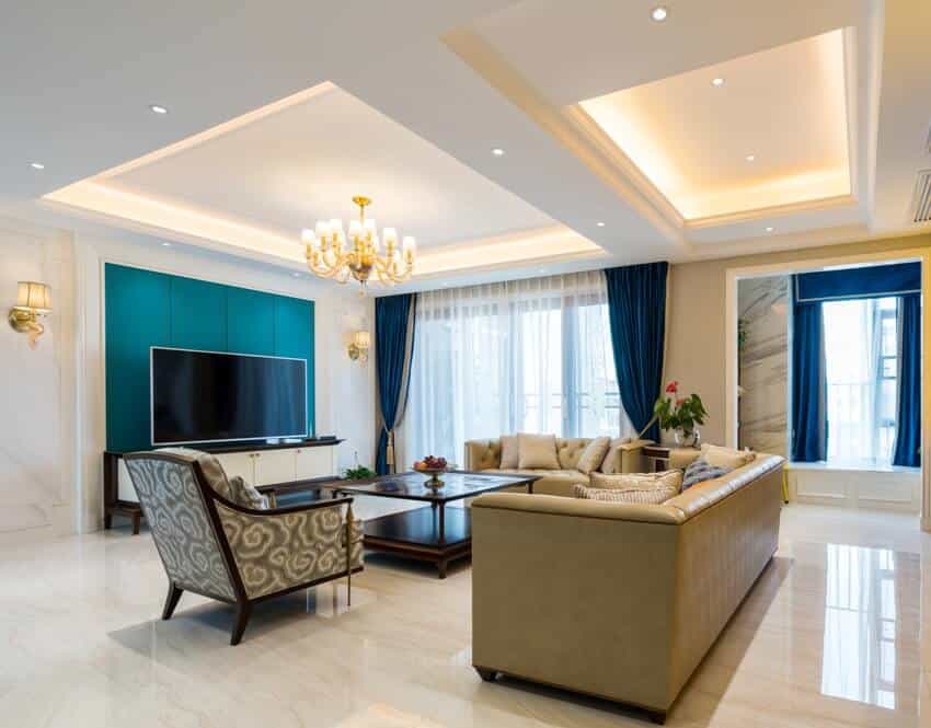 Room with stepped ceiling, cream sofa and blue curtains