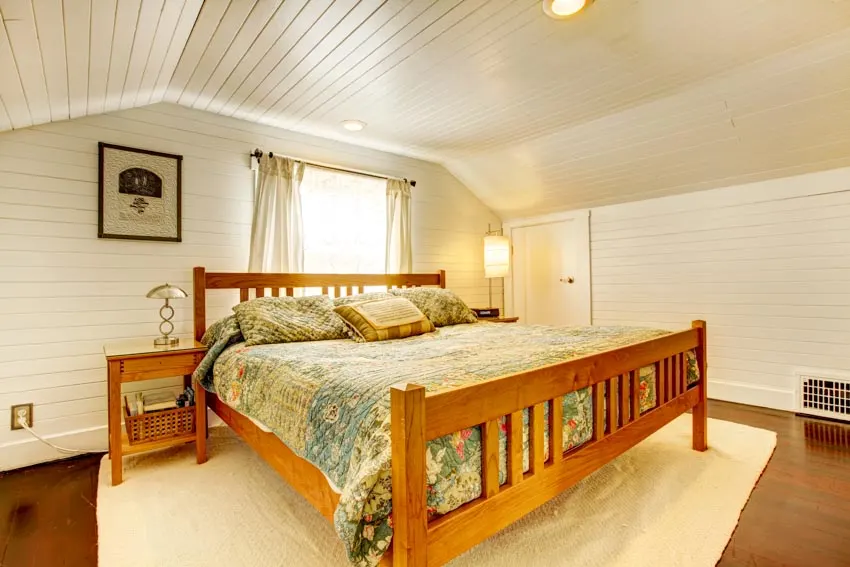 Bedroom with white ceiling, wood bed and white area rug