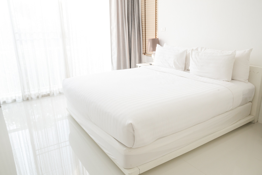 Bedroom with fitted sheets, pillows, curtains, and mini blinds