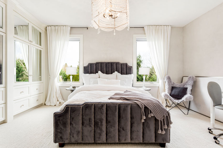 Спальня с французским карнизом для штор, кроватью, изголовьем кровати, окнами, потолочным освещением, шкафами, зеркалом и стульями