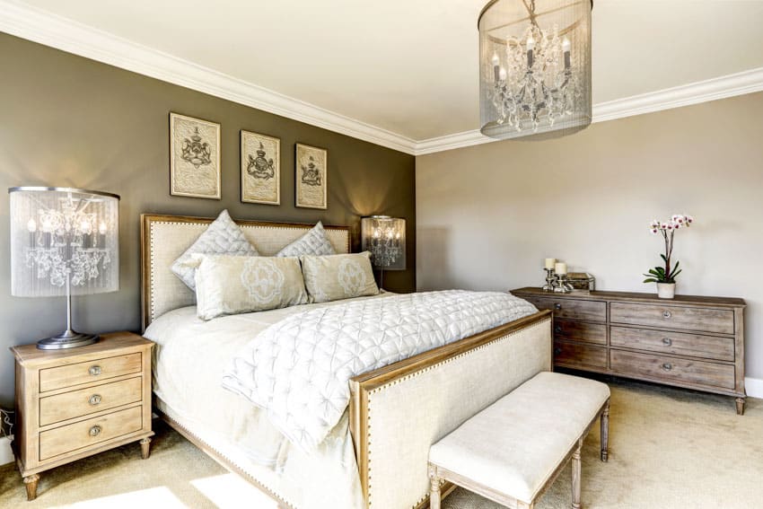 Bedroom with nightstand, lamp, footboard, headboard, dresser, table, pillows, and lamp