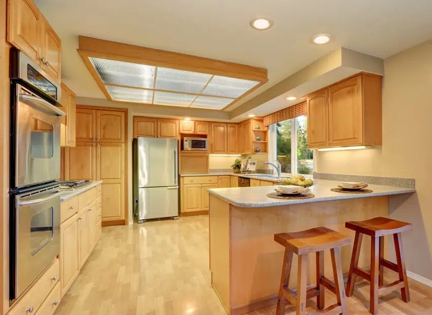 Kitchen with steel appliances and fiberglass panels ceiling with lighting 