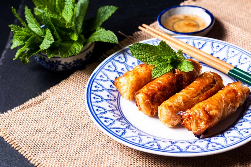 China plate with dipping sauce, appetizer, and chopsticks