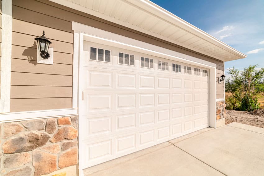 Climate controlled garage with insulated door, siding, and wall mounted light