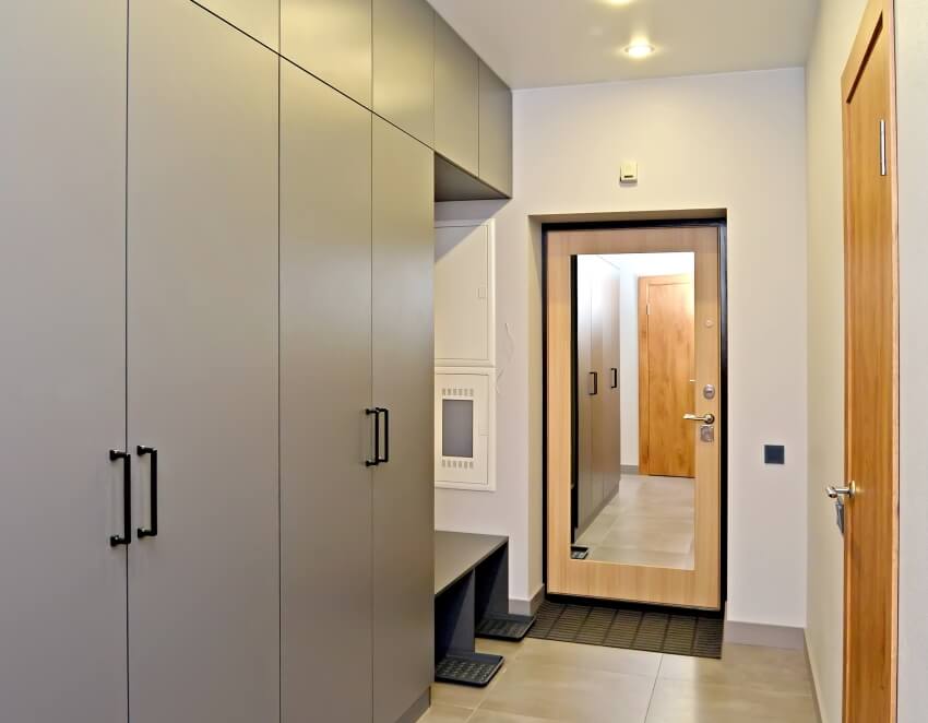 A closet with cabinets and murphy door with mirror