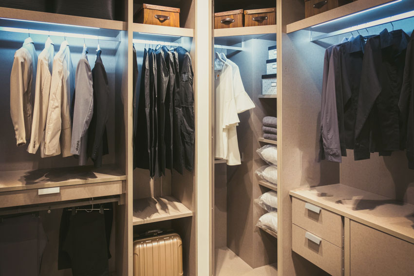 Closet with shelves, drawers, hangers, and lighting fixtures