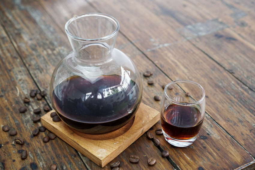 Coffee decanter with glass on top of wood counter