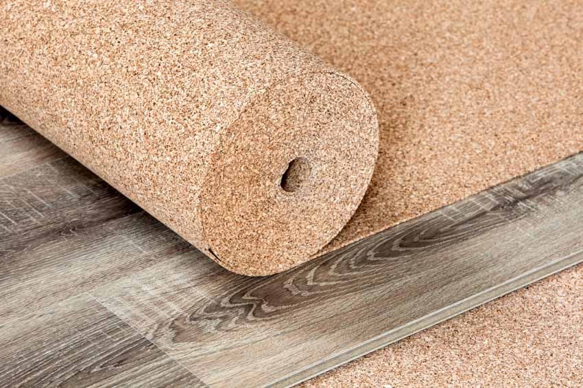 Cork flooring roll on top of wood laminate planks for home interiors