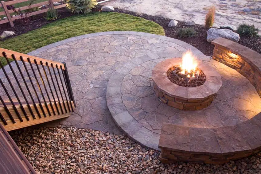 Decomposed granite and flagstone patio with fire pit and curved bench