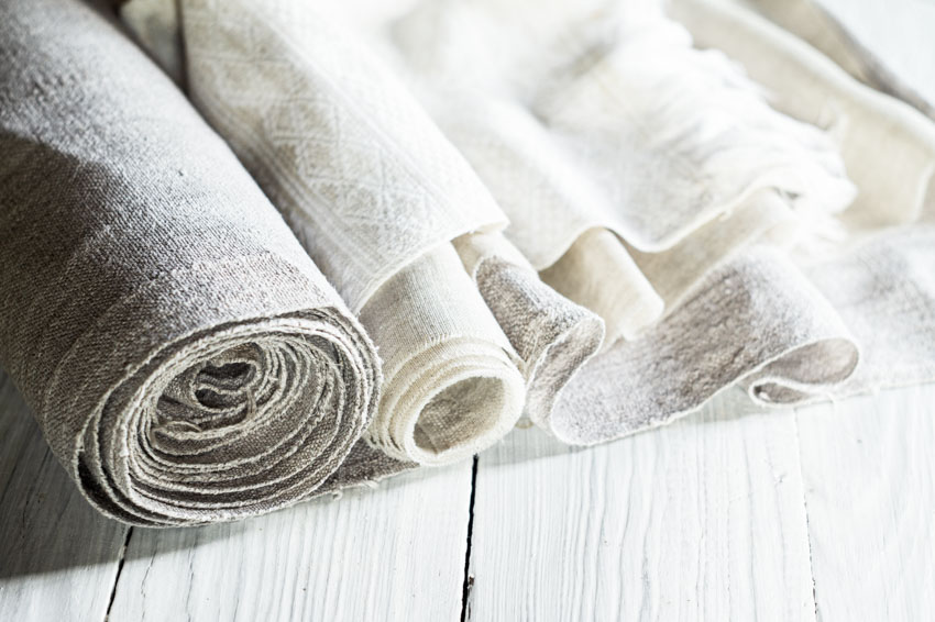 Different types of linen fabric on wood surface