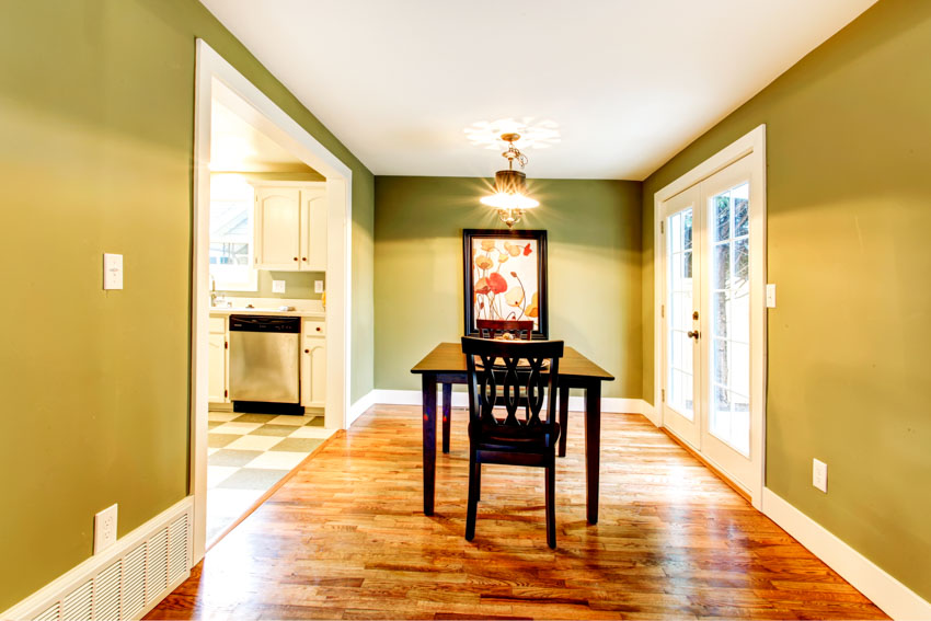 Dining room painted in olive and large baseboard