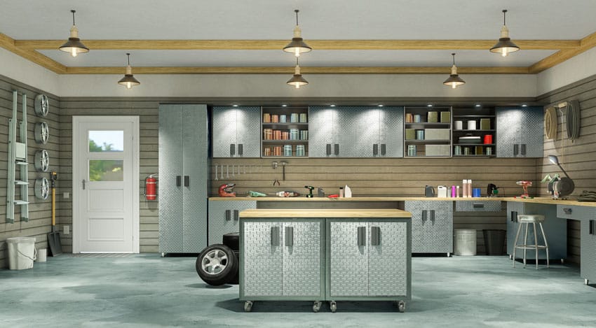Garage with shiplap walls, cabinets, workspace, island, door, and pendant lights