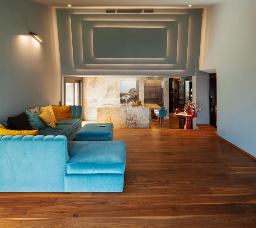 A home villa interior with artistic wall design, blue sofa and solid wood mahogany flooring