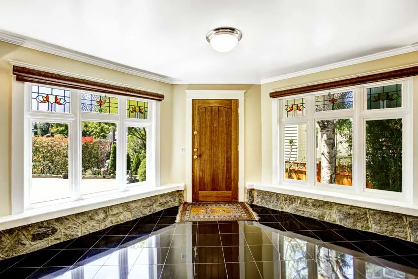 House entranceway with wood door, flush lighting and glass panel windows
