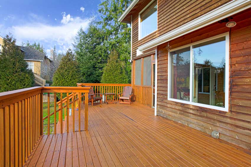 House exterior with pressure treated wood deck, house siding, windows, and railings