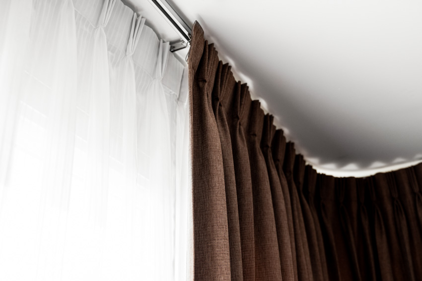 House interior with brown and white curtain, and curved curtain rod