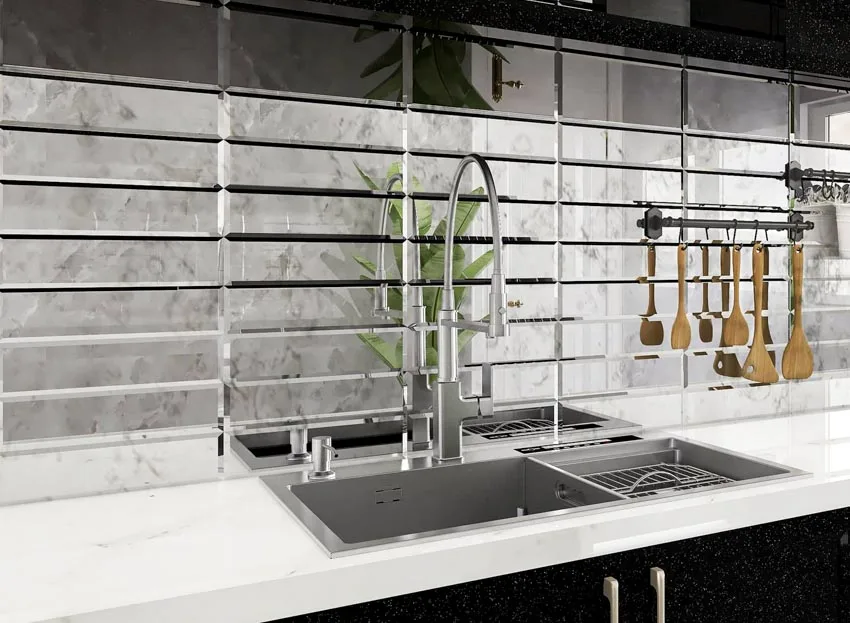 Industrial kitchen with distressed mirror backsplash, countertop, sink, and faucet