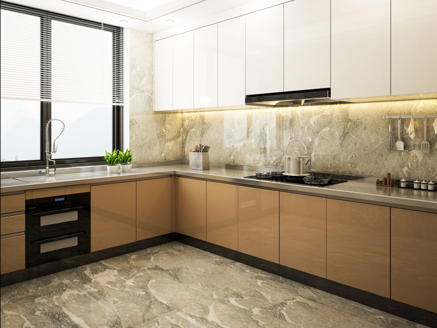 Kitchen with backlit onyx backsplash, cabinets, countertop, stove, range hood, and window