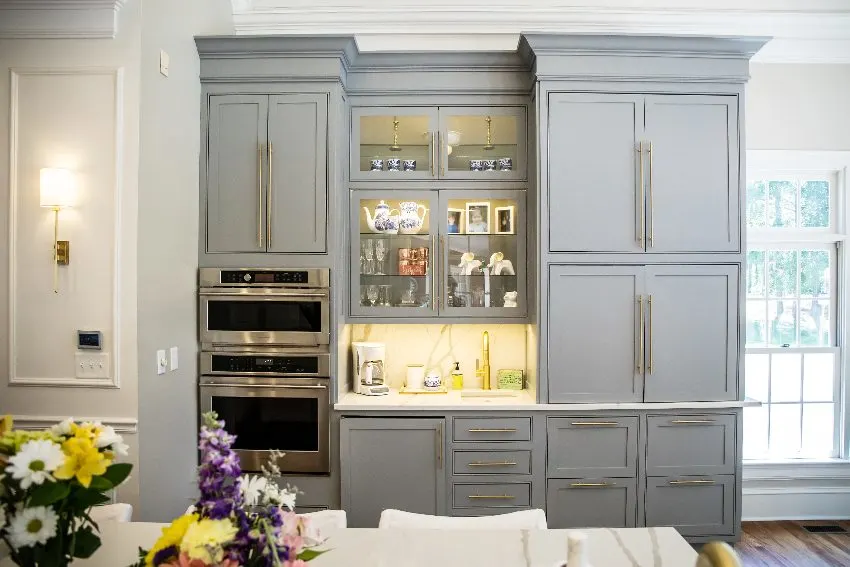 Kitchen with custom made gray inset cabinets with built in oven and other decors