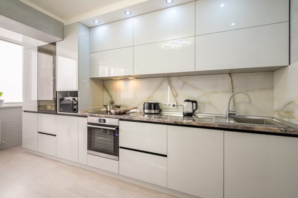 Onyx Backsplash Designs Pros And Cons   Kitchen With White Onyx Backsplash Cabinets Countertop Oven Sink And Windows Is 608x405 