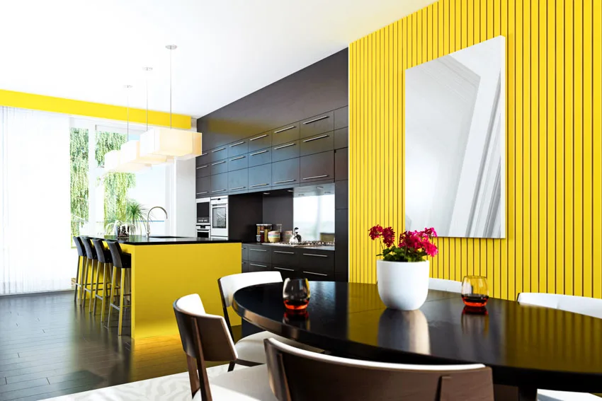Kitchen with yellow painted slat wall, cabinets, dining area, chairs, table, and window
