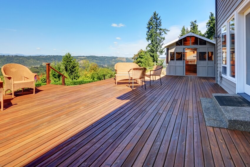 Large walkout Douglas fir deck with wicker furniture and perfect landscape view 