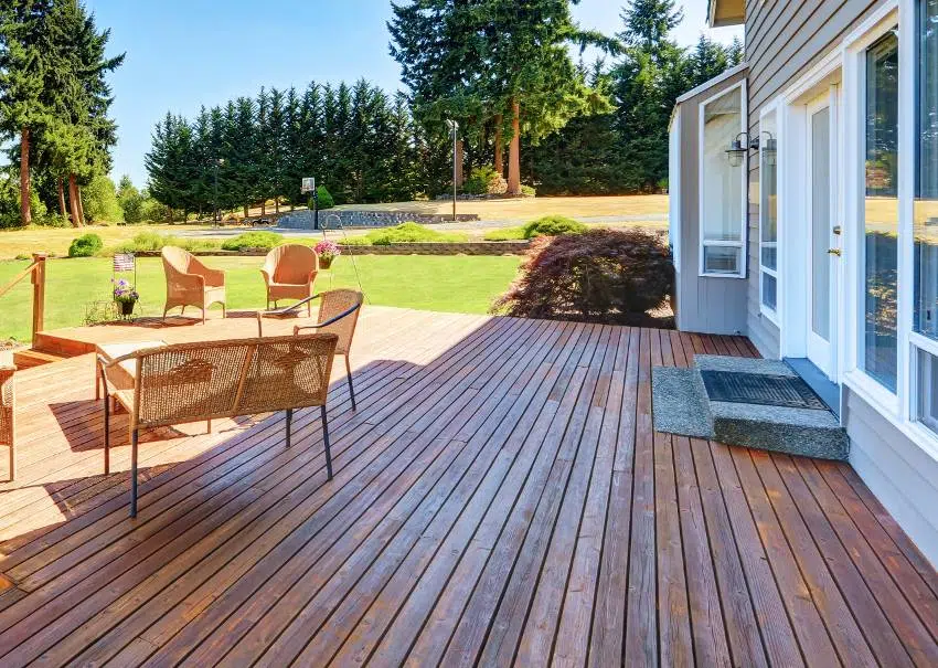 A large walkout teak deck with wicker furniture and perfect landscape view